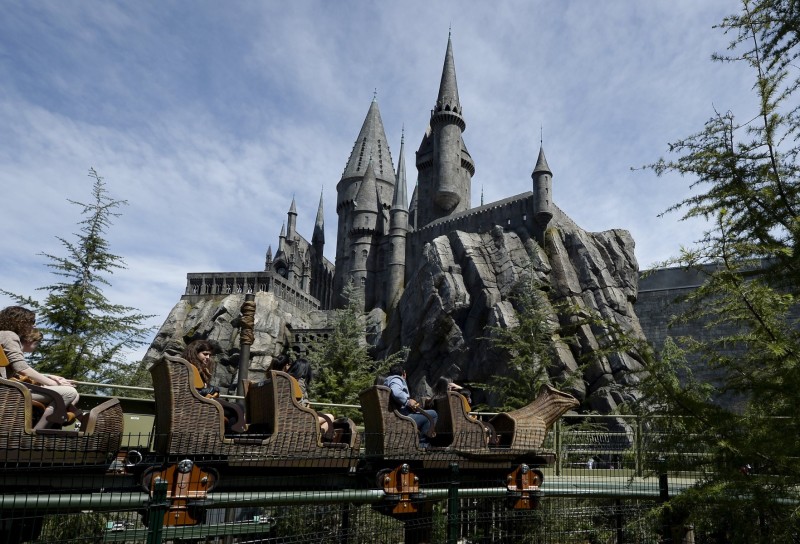 Guests take a ride on a rollercoaster outside the Hogwarts School during a soft opening and media tour of "The Wizarding World of Harry Potter" theme park at the Universal Studios Hollywood in Los Angeles, California in this picture taken March 22, 2016. REUTERS/Kevork Djansezian